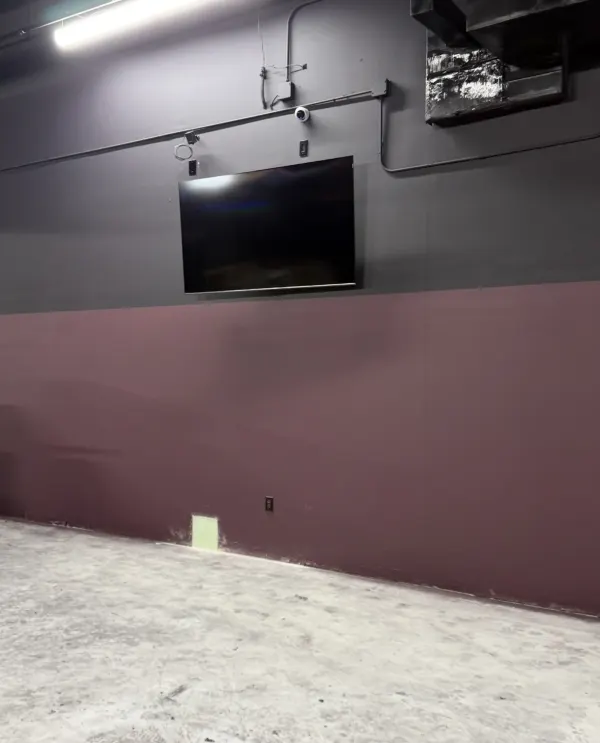 Wall-mounted display and dome IP security camera with conduit run by BVTech at Outlaw Pickle